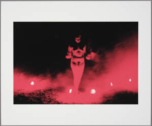 Print of a nude woman standing amid red flares and smoke