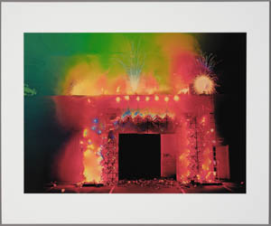 Print of a building adorned with orange fireworks with green and yellow fireworks sprouting from the roof