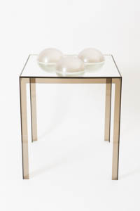 Clear acrylic table with three opaque mirrored domes sitting on top