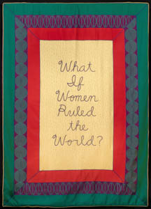 Textile with handwritten text in the center framed in rectangles of red, a purple pattern, and green