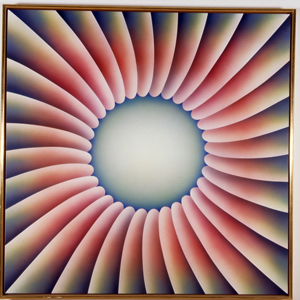 Framed canvas with blue, yellow, and pink gradated petal shapes leading towards a centered jagged blue circle