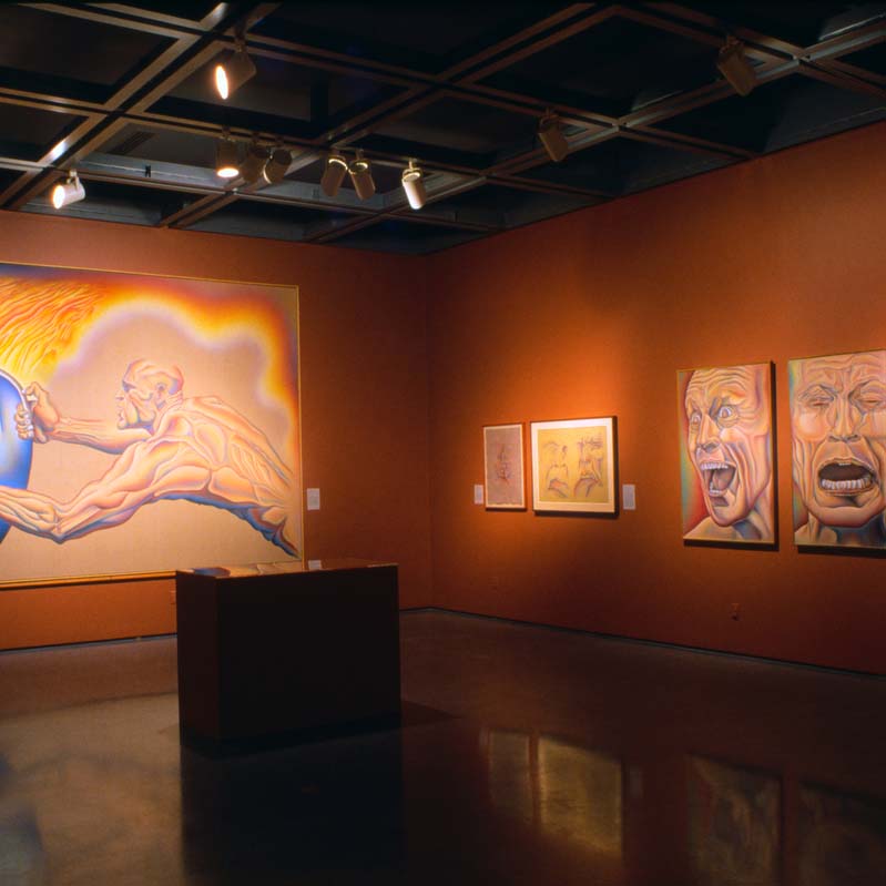 Color photograph of six artworks installed on adjacent dark orange walls
