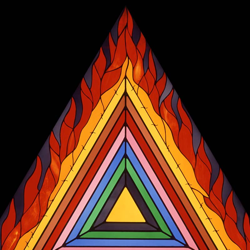 Stained glass work of a flaming, rainbow-striped triangle