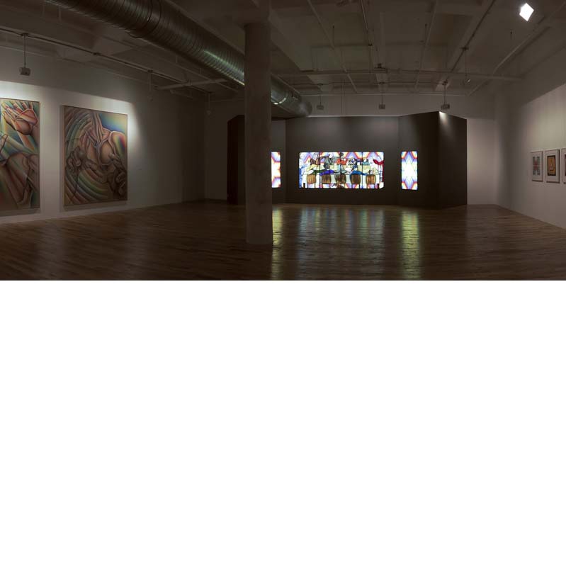 Color photograph of paintings and a stained glass work in a gallery with white walls