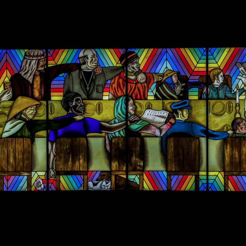 Stained glass work of people of different faiths and races sitting around a table