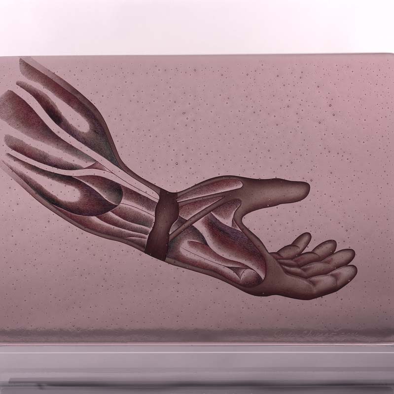 Sculpture of an outstretched hand painted in shades of brown on a translucent pink rectangle on a clear plinth