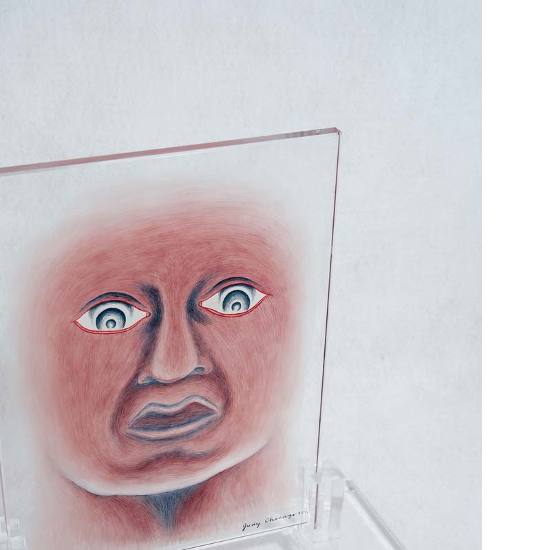 Pink and black painting of a face with large eyes and an open mouth on a clear glass rectangle on a clear plinth