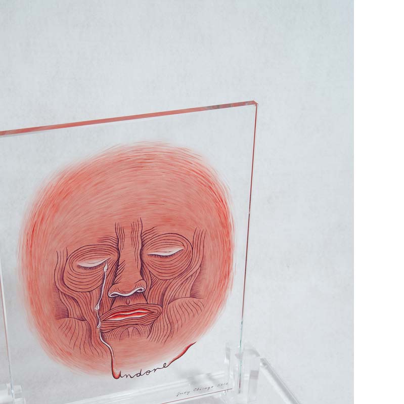 Painting in shades of pink of a wrinkled face crying on a clear glass rectangle on a clear plinth