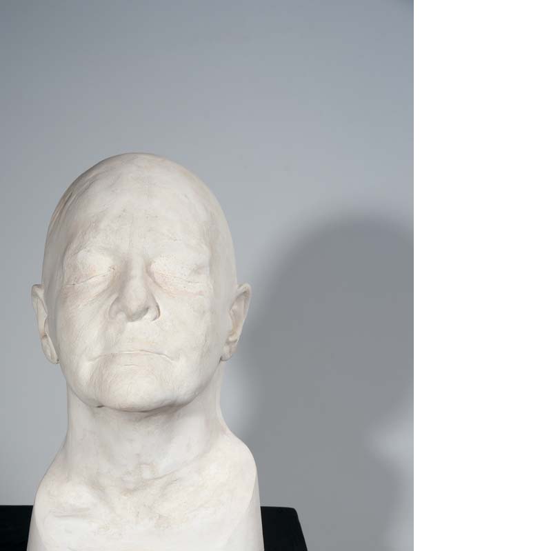 Sculpture in white of a bald head on a black plinth