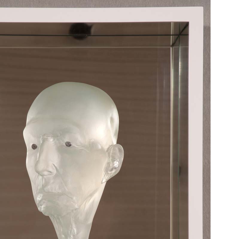 Relief sculpture of a translucent white bald head on a mirrored background
