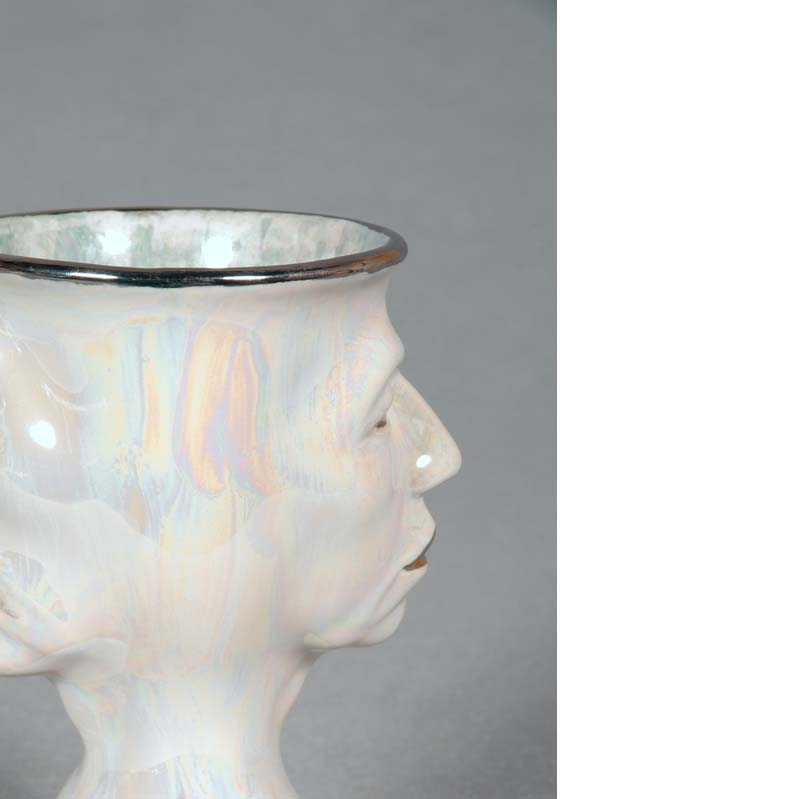 Mug in white and metallic silver with a face on either side and a flared base