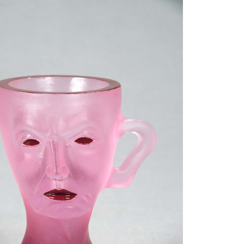 Mug in translucent pink with a face, handle, and a flared base