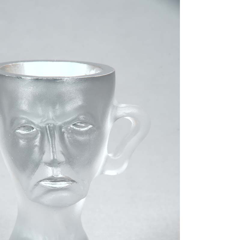 Mug in translucent white with a face, handle, and a flared base