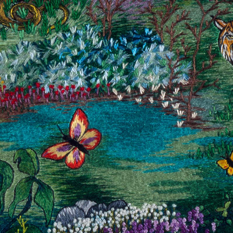 Color embroidery of a tiger and two butterflies in a lush garden
