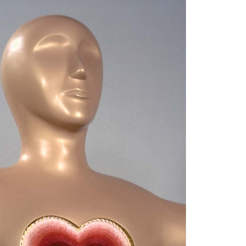 Red, purple, and gold embroidery heart mounted on the chest of a beige sculptural figure