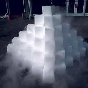 Color photograph of a pyramid of white blocks with white fog emanting from it