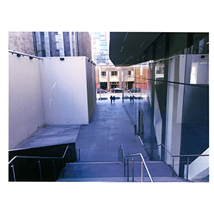 Color photograph of an outdoor walkway with stairs between two buildings
