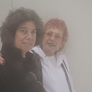 Color photograph of Judy Chicago with her arm around Diane Gelon