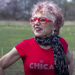 Color photograph of Judy Chicago with a lawn in the background