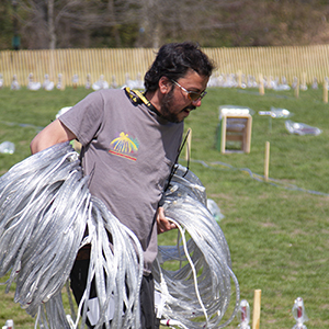 Color photograph of Rusty Johnson carrying large loops of wire